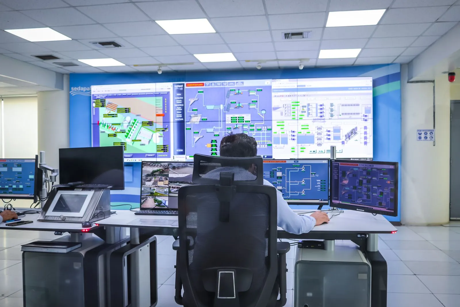 An operator watching plant-monitoring screens in a control room